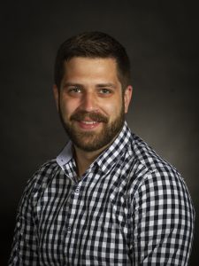 A photo of Richard Buote, RPI Consultant. Richard is wearing a checkered shirt. He has dark hair and a beard, and he is smiling.